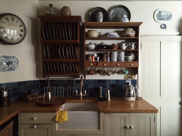 white kitchen cabinets and a shelf with dishes arranged above it